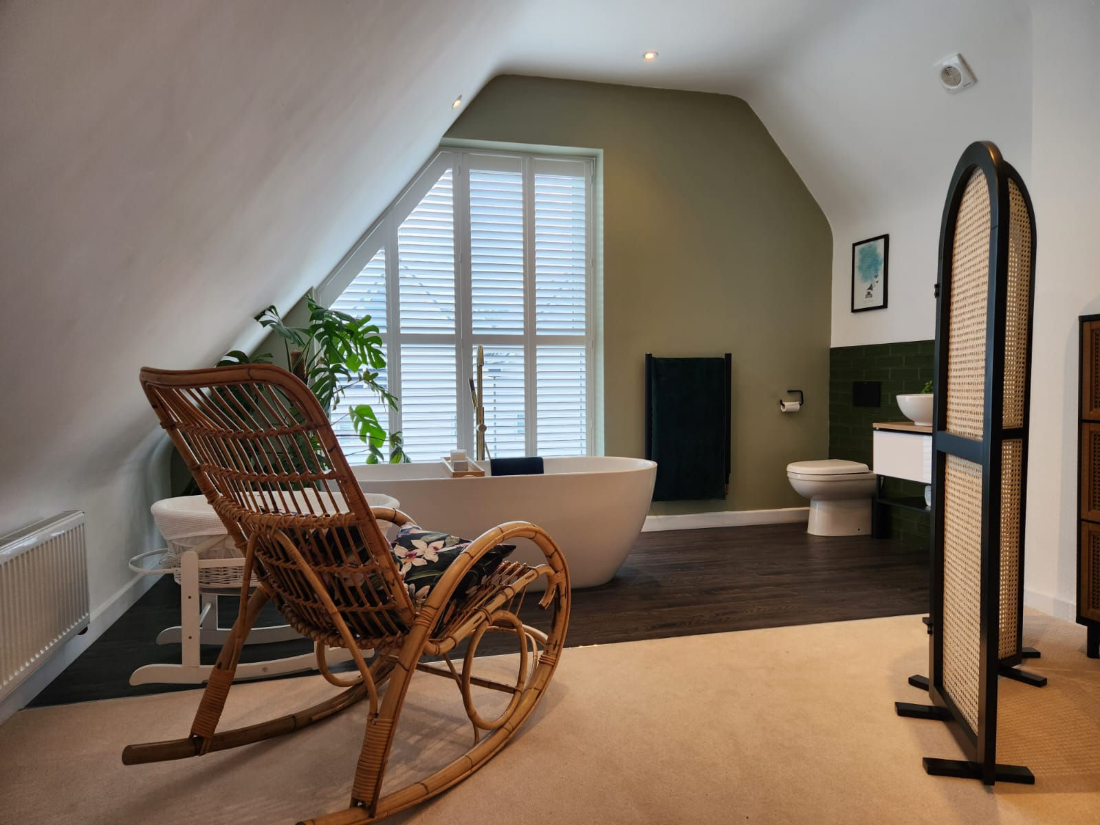 Bespoke shaped shutters in a bathroom with a freestanding bath