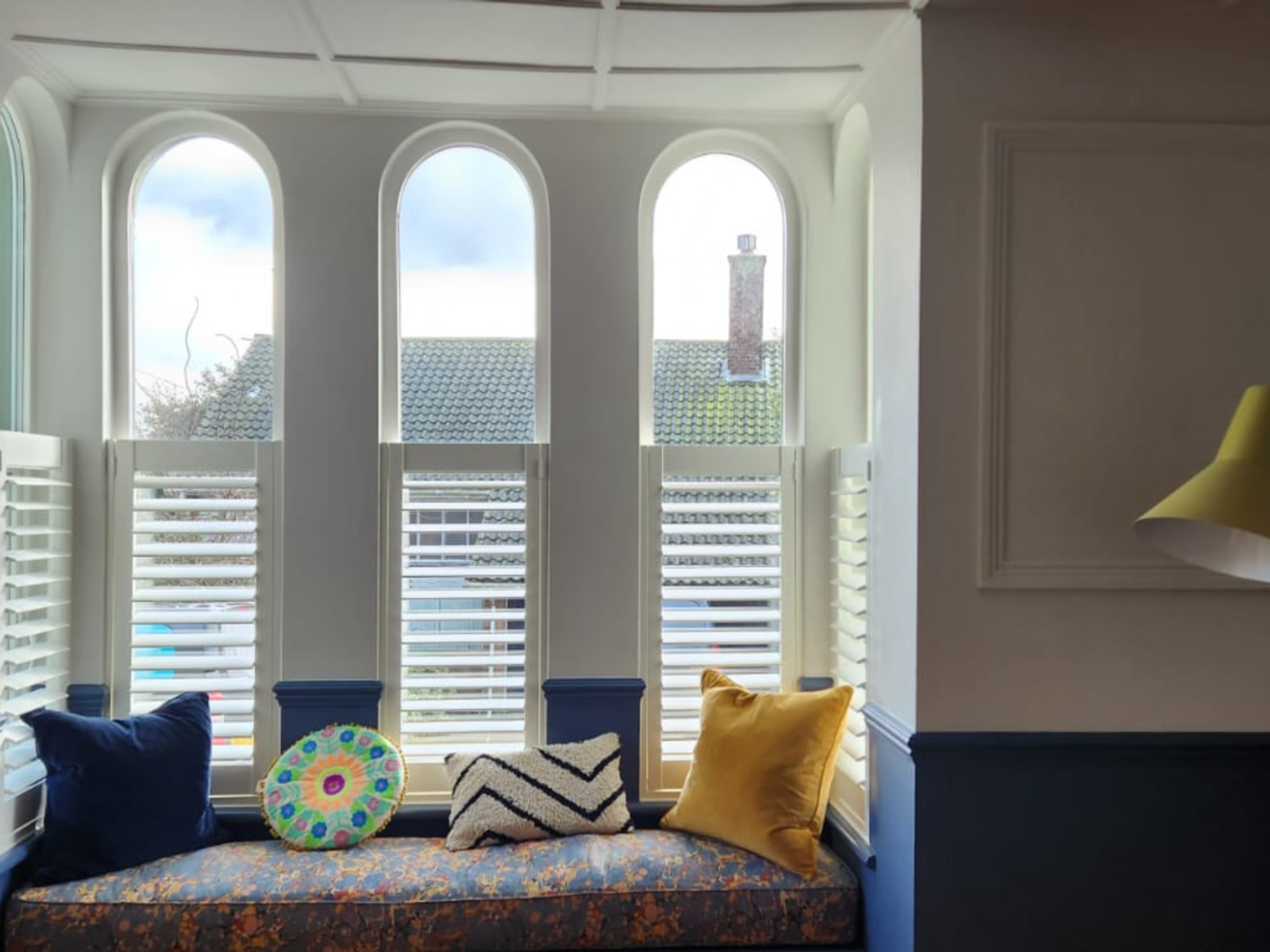 Café style shutters on an arched bay window seat